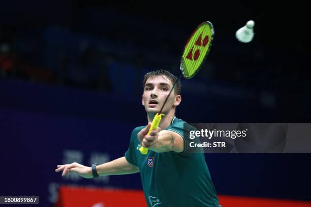 France's Christo Popov hits a return to Japan's Kanta Tsuneyama during their men's singles quarterfinal match of the BWF World Tour China Masters...