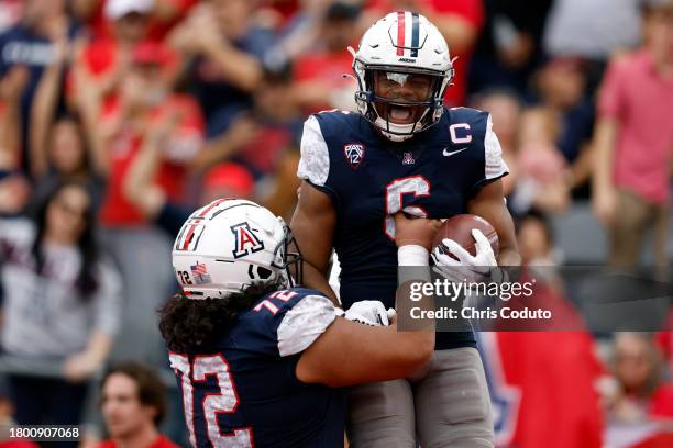 Running back Michael Wiley of the Arizona Wildcats reacts with offensive lineman Wendell Moe after scoring a touchdown against the Utah Utes during...