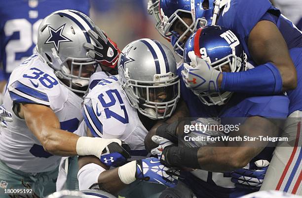 Dallas Cowboys defensive back Jeff Heath and DeVonte Holloman hit New York Giants running back Michael Cox at AT&T Stadium in Arlington, Texas, on...