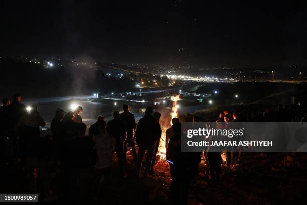 People gather on a hill overlooking the Israeli Ofer military facility in Baytunia in the occupied West Bank as they wait for the release of...