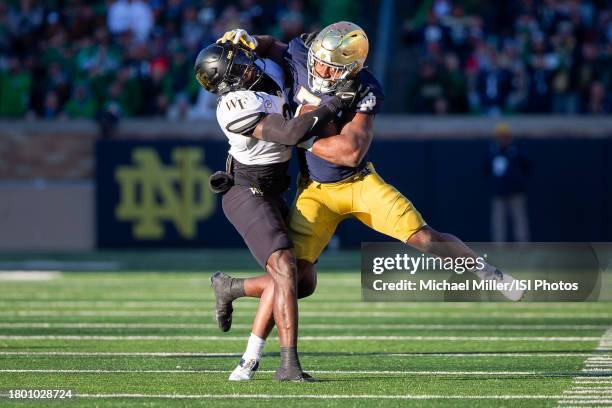 Audric Estime of Notre Dame is tackled by Malik Mustapha of Wake Forest during a game between Wake Forest University and University of Notre Dame at...