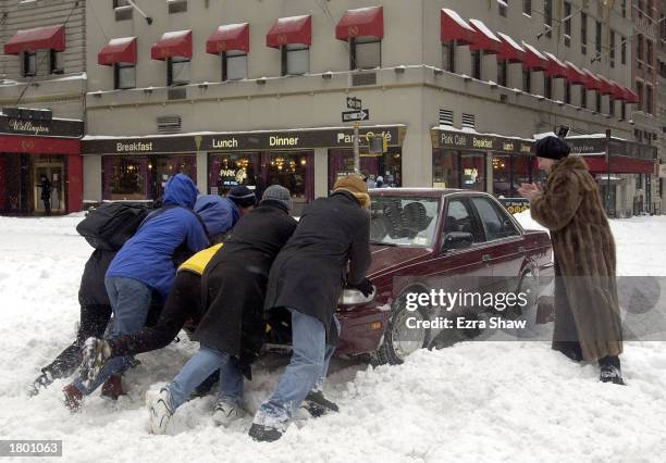 People helped push a car stuck on Seventh Avenue during a snow storm February 17, 2003 in New York City. Billed as the worst snowstorm in seven...