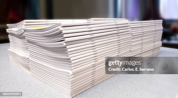 stacks of white pamphlets on a white counter - pamphlet stock pictures, royalty-free photos & images