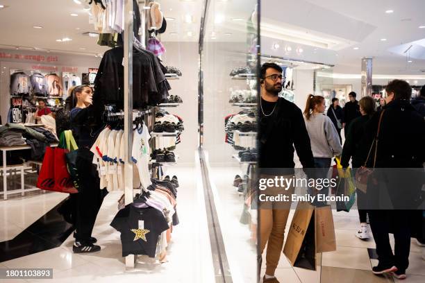 Shoppers look at clothes while others walk around Twelve Oaks Mall on November 24, 2023 in Novi, Michigan. The National Retail Federation projects...