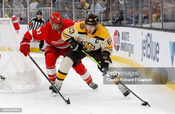 Brad Marchand of the Boston Bruins is chased by Shayne Gostisbehere of the Detroit Red Wings during the first period at the TD Garden on November 24,...