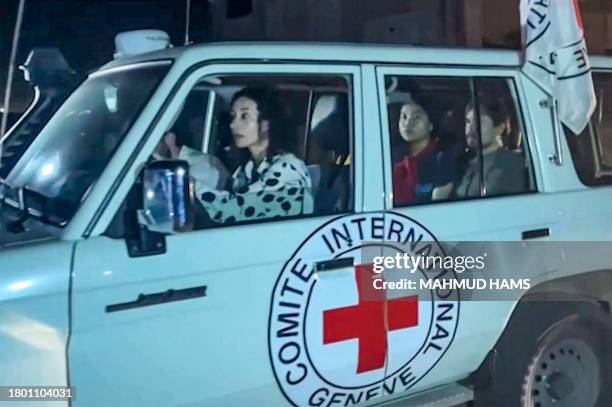 This image grab taken from an AFPTV video footage shows an International Red Cross vehicle reportedly carrying hostages released by Hamas crosses the...