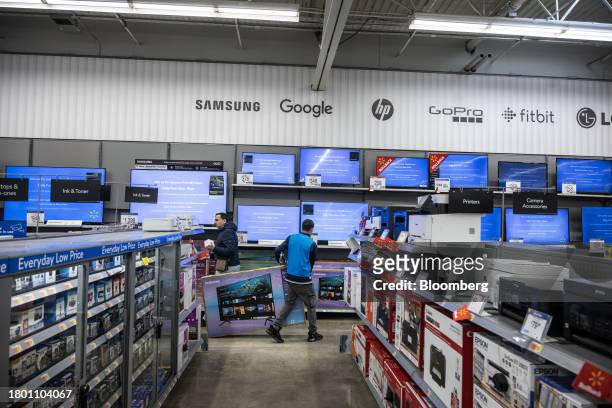 Worker stocks televisions at a Walmart store on Black Friday in Secaucus, New Jersey, US, on Friday, Nov. 24, 2023. An estimated 182 million people...