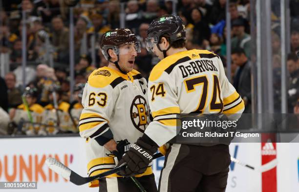 Brad Marchand of the Boston Bruins talks to teammate Jake DeBrusk during a game against the Detroit Red Wings during the first period at the TD...