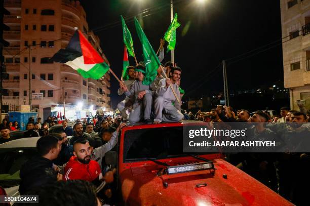 People cheer as Palestinian prisoners that were released from the Israeli Ofer military facility in exchange for hostages freed by Hamas in Gaza,...