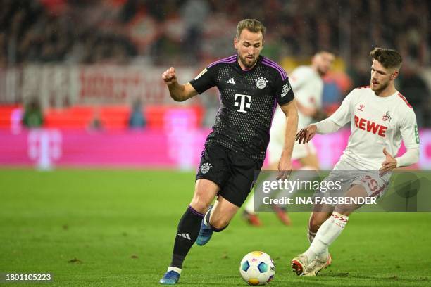 Bayern Munich's English forward Harry Kane and Cologne's German midfielder Jan Thielmann vie for the ball during the German first division Bundesliga...