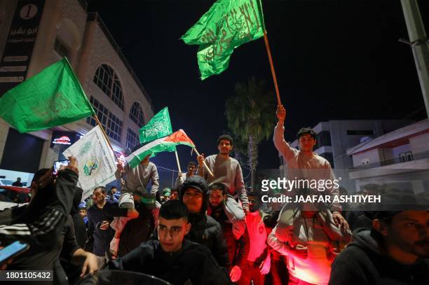 Palestinian prisoners that were released from the Israeli Ofer military facility in exchange for hostages freed by Hamas in Gaza, wave flags and...