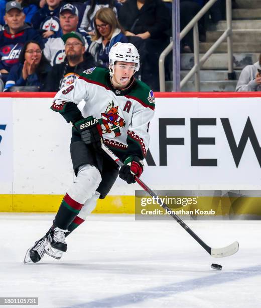 Clayton Keller of the Arizona Coyotes plays the puck during second period action against the Winnipeg Jets at Canada Life Centre on November 18, 2023...