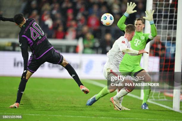 Bayern Munich's German goalkeeper Manuel Neuer and Cologne's Danish defender Rasmus Carstensen vie for the ball during the German first division...