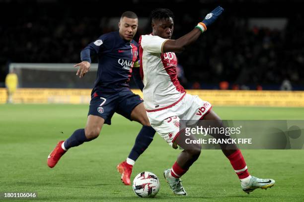 Paris Saint-Germain's French forward Kylian Mbappe and Monaco's Ivorian defender Wilfried Singo fight for the ball during the French L1 football...