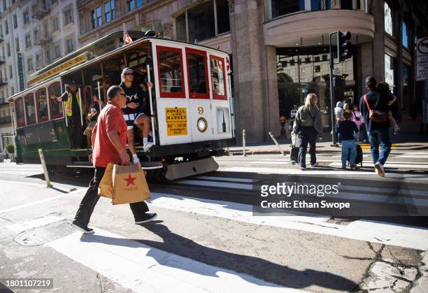 Shopper walks past a cable car on November 24, 2023 in Union Square, San Francisco, California. The National Retail Federation projects that an...