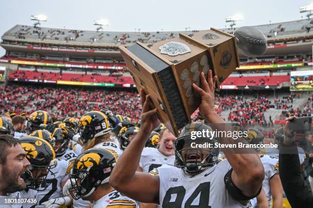 Defensive lineman Yahya Black of the Iowa Hawkeyes holds up the Heroes Game Trophy after the win against the Nebraska Cornhuskers at Memorial Stadium...