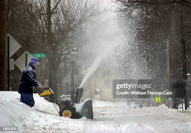 Man uses a snow blower to remove snow from his driveway after a winter winter snowstorm February 17, 2003 in Doylestown, Pennsylvania. A winter...