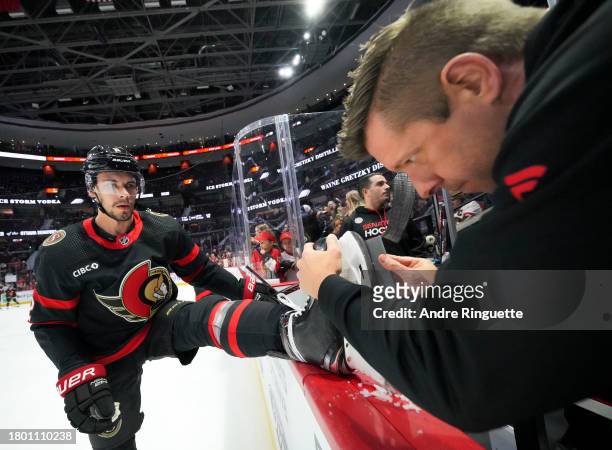 Equipment manager John Forget of the Ottawa Senators sharpens the skates of Artem Zub during warmup prior to a game against the New York Islanders at...