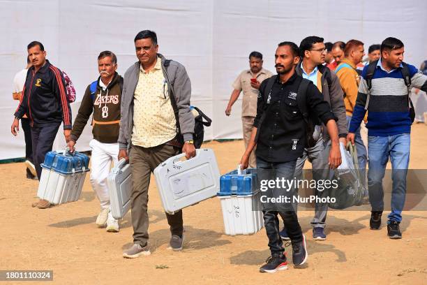 Polling officials are leaving with EVMs and other election materials for poll duty on the eve of the Rajasthan Assembly elections in Jaipur,...