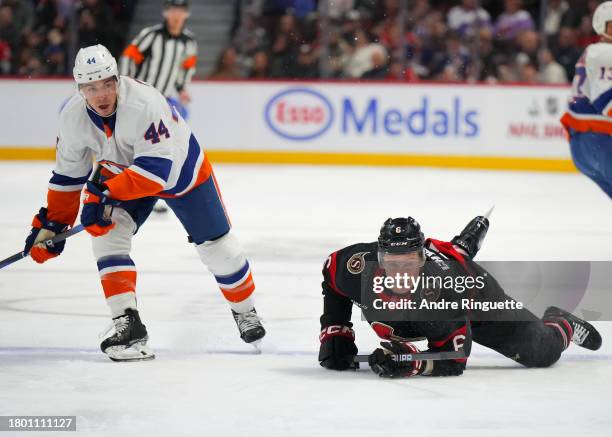 Jakob Chychrun of the Ottawa Senators gets tripped by Jean-Gabriel Pageau of the New York Islanders drawing a penalty during the first period at...