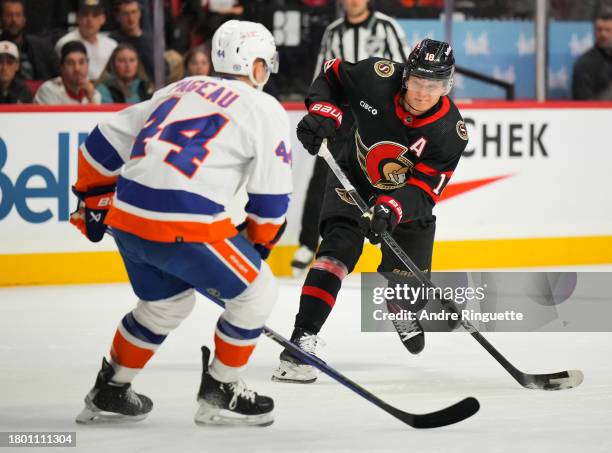 Tim Stützle of the Ottawa Senators shoots the puck against Jean-Gabriel Pageau of the New York Islanders during the first period at Canadian Tire...