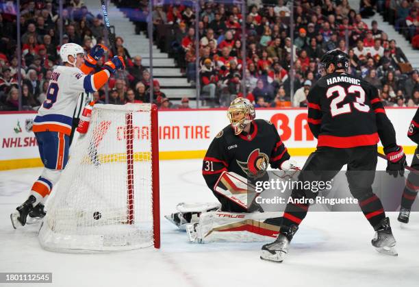 Mathew Barzal of the New York Islanders scores a second period goal against Anton Forsberg of the Ottawa Senators as Brock Nelson of the New York...