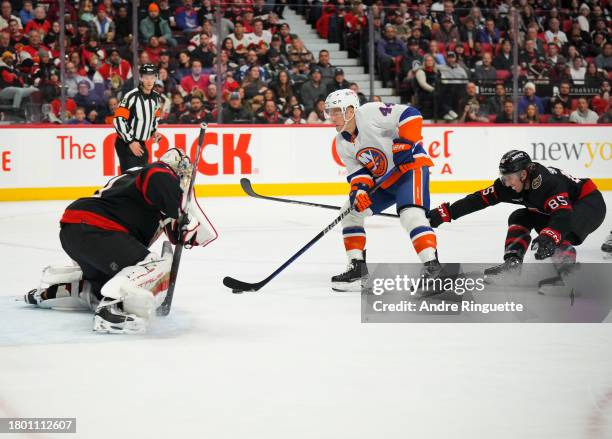 Jean-Gabriel Pageau of the New York Islanders shoots the puck against Anton Forsberg of the Ottawa Senators as Jake Sanderson defends during the...