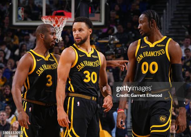 Chris Paul, Stephen Curry and Jonathan Kuminga of the Golden State Warriors looks on during the In-Season Tournament against the San Antonio Spurs on...