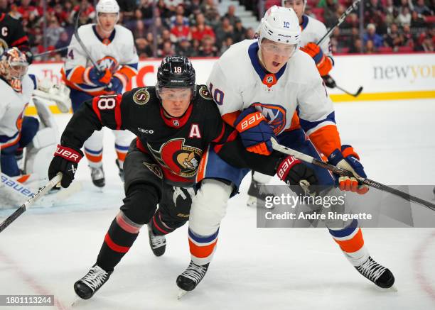 Tim Stützle of the Ottawa Senators battles for position against Simon Holmstrom of the New York Islanders during the third period at Canadian Tire...