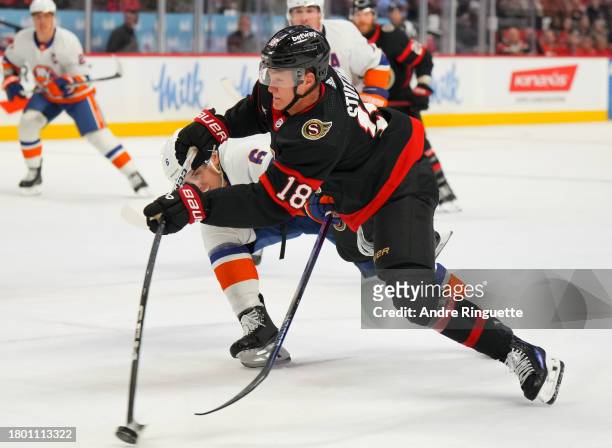 Tim Stützle of the Ottawa Senators shoots the puck against Ryan Pulock of the New York Islanders during the third period at Canadian Tire Centre on...