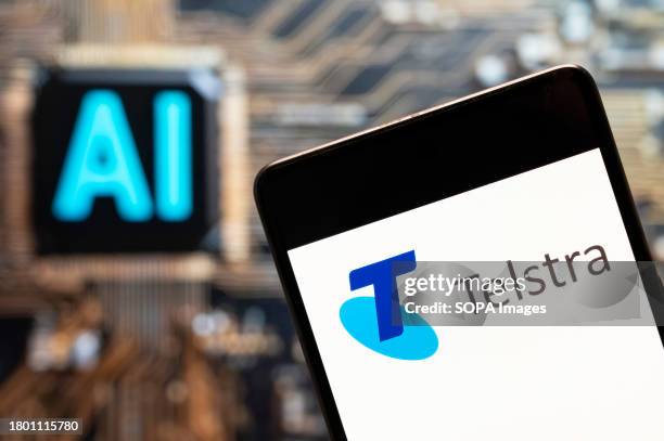 In this photo illustration, the Australia's largest telecommunications company Telstra logo seen displayed on a smartphone with an Artificial...