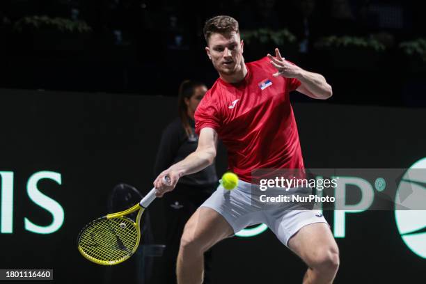 Miomir Kecmanovic of Serbia is playing a forehand during the quarterfinal match against Jack Draper of Great Britain at the Davis Cup in Malaga,...