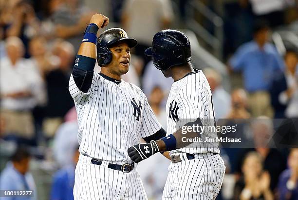 Alfonso Soriano of the New York Yankees celebrates his eighth inning two run home run against the Toronto Blue Jays with teammate Robinson Cano at...