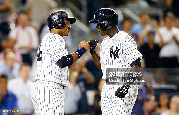 Alfonso Soriano of the New York Yankees celebrates his eighth inning two run home run against the Toronto Blue Jays with teammate Robinson Cano at...