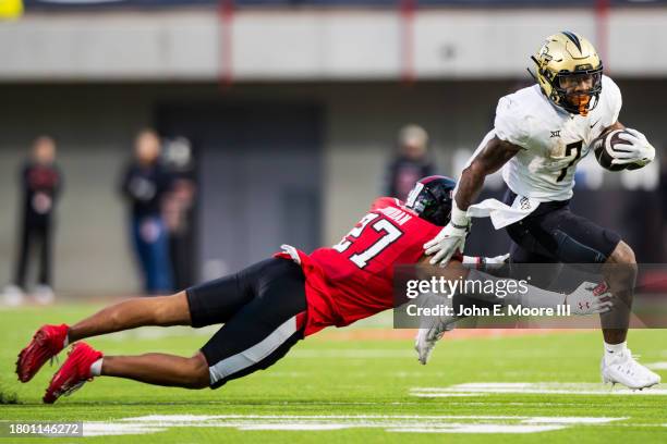 Harvey of the UCF Knights runs away from Brenden Jordan of the Texas Tech Red Raiders during the first half of the game at Jones AT&T Stadium on...