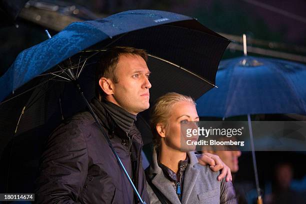 Alexey Navalny, Russian opposition leader, and his wife Yulia, shelter beneath an umbrella during a pre-election rally for Moscow's mayoral election...