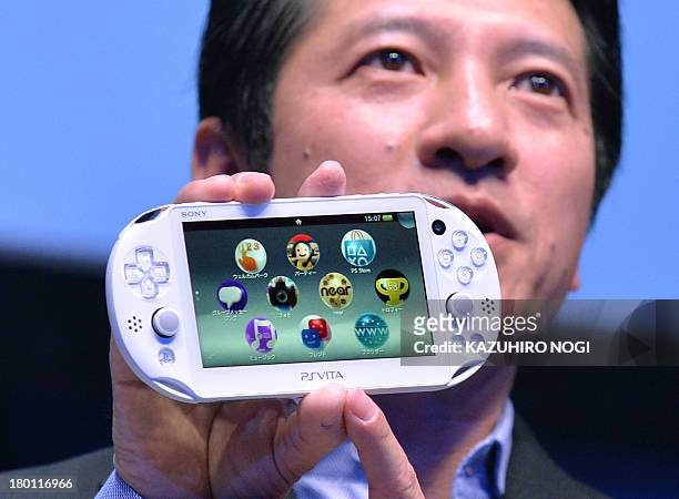 Hiroshi Kawano, President of Sony Computer Entertainment Japan Asia , displays the company's new handheld PlayStation Vita during the SCEJA press...