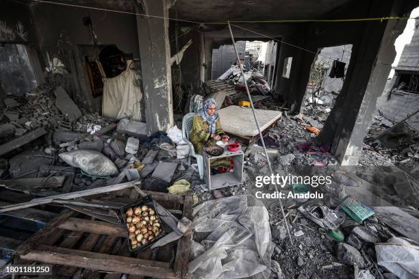 Haleed Naci and his family cook food as they continue their daily lives among the rubble and debris of their family house destroyed by Israeli...
