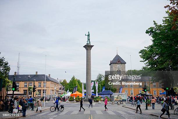 Pedestrians cross a city square filled with political campaigners ahead of national elections in Trondheim, Norway, on Saturday, Sept. 8, 2013....