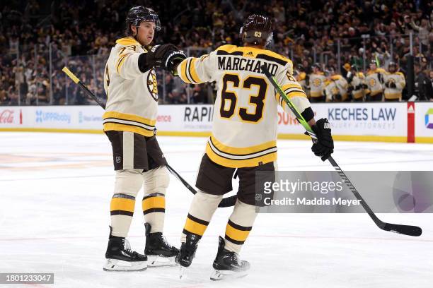 Charlie McAvoy of the Boston Bruins celebrates with Brad Marchand after scoring against the Montreal Canadiens during the first period at TD Garden...