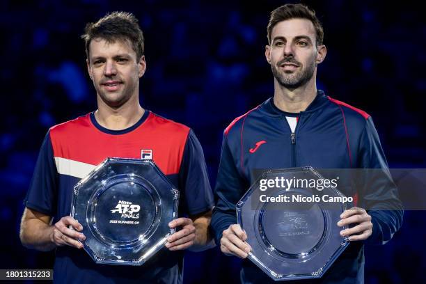 Horacio Zeballos of Argentina and Marcel Granollers of Spain hold the trophies for the second place at the end of the final doubles match against...