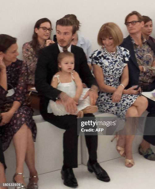 Soccer star David Beckham with daughter Harper and celebrity editor of Vogue Anna Wintour watch as designer wife Victoria Beckham unveils her new...