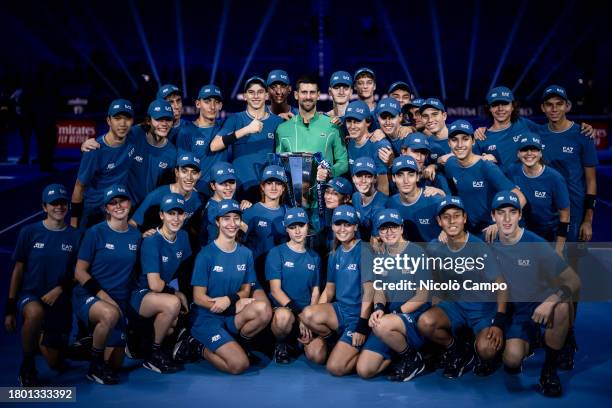 Novak Djokovic of Serbia holding the trophy poses with ball boys at the end of the final singles match against Jannik Sinner of Italy during day...