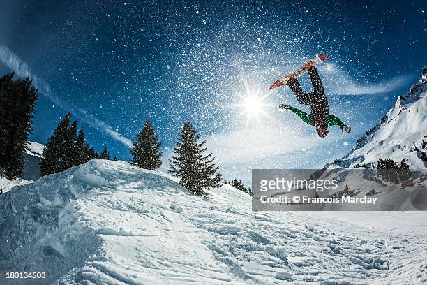 snowboarder doing a backflip with snow exploding - backflipping imagens e fotografias de stock