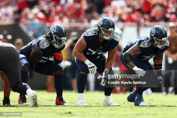 Aaron Brewer, Peter Skoronski, and Dillon Radunz of the Tennessee Titans line up before a play during an NFL football game against the Tampa Bay...