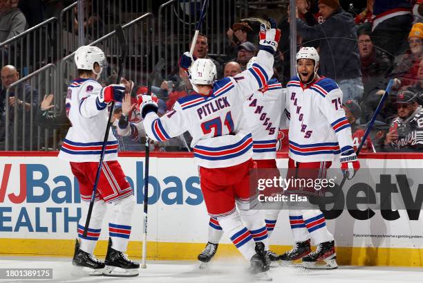 Jimmy Vesey of the New York Rangers is congratulated by teammates K'Andre Miller,Tyler Pitlick and Jacob Trouba of the New York Rangers after Vesey...