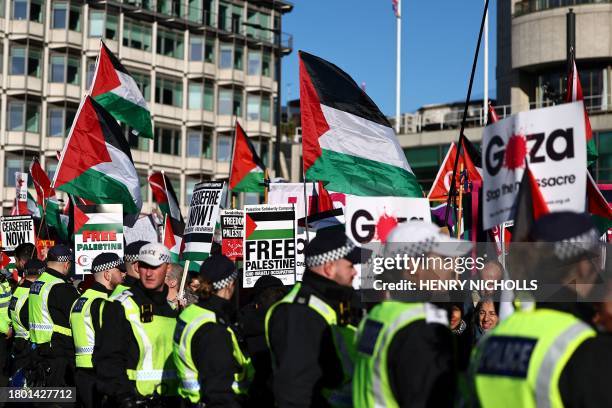 Metropolitan Police officers gather as protesters holding placards and Palestinian flags take part in a 'National March For Palestine' in central...