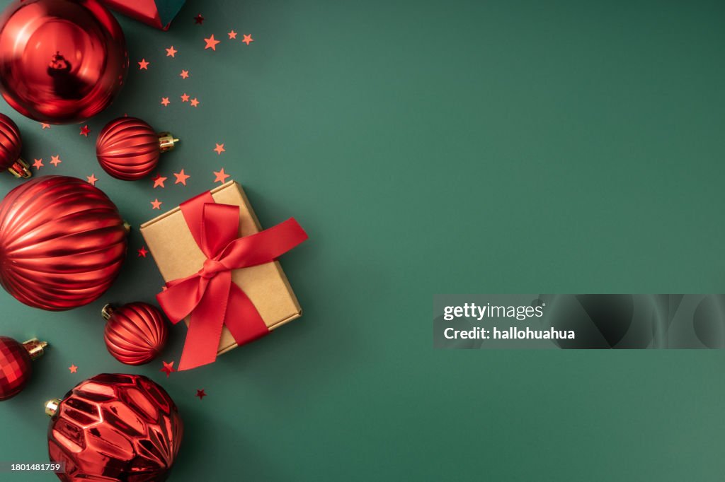 Christmas or Happy New Year background. Gift boxes with holiday decorations on green background. Flat lay.