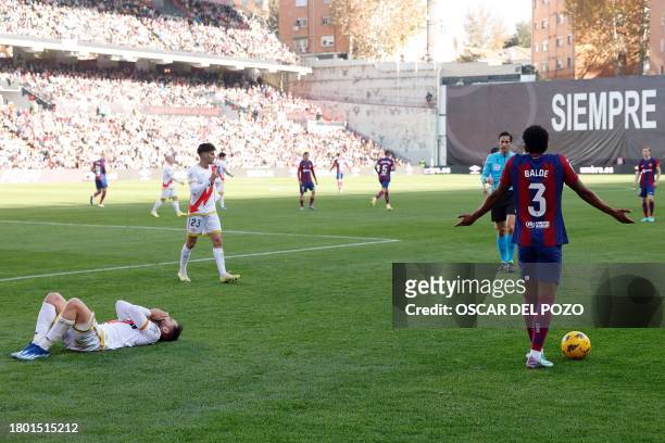 Barcelona's Spanish defender Alejandro Balde gestures as Rayo Vallecano's Spanish midfielder Unai Lopez reacts after a fall during the Spanish league...