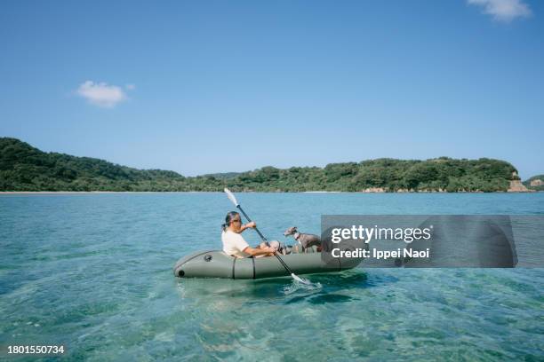 man sea kayaking with dog through tropical lagoon - bote neumático fotografías e imágenes de stock